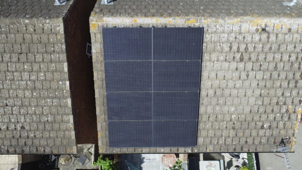 Vertical row of solar PV panels installed on one half of a roof.