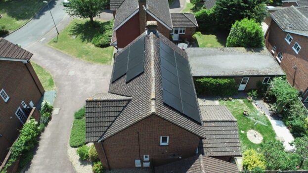 Overhead of a house with solar PV panels on both sides of the roof.