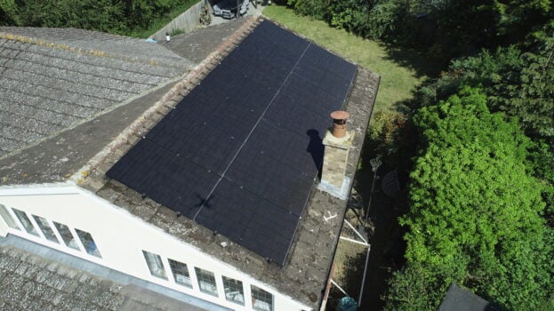 Solar PV panels installed on a roof with a chimney.