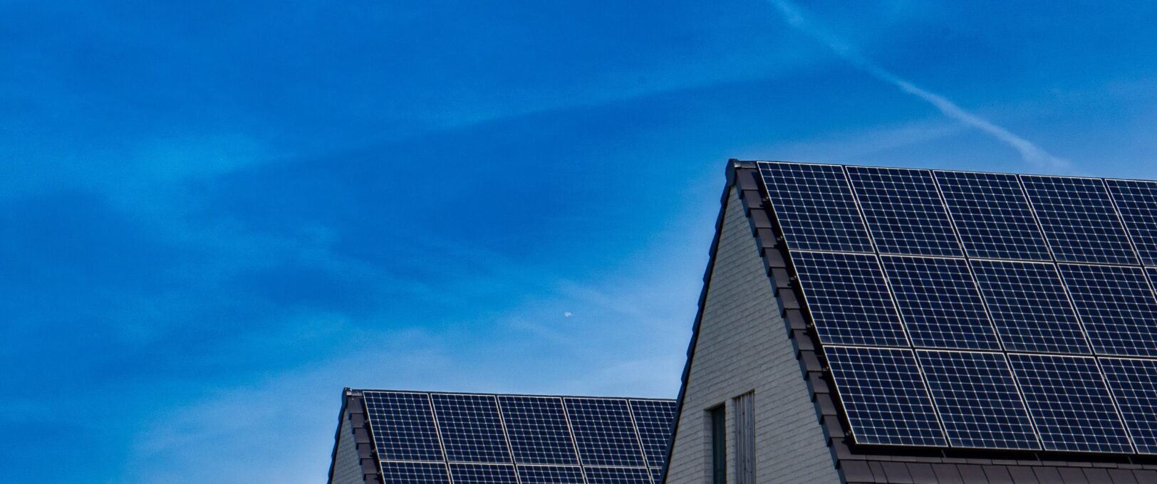A row of houses with solar PV panels installed on the roofs.